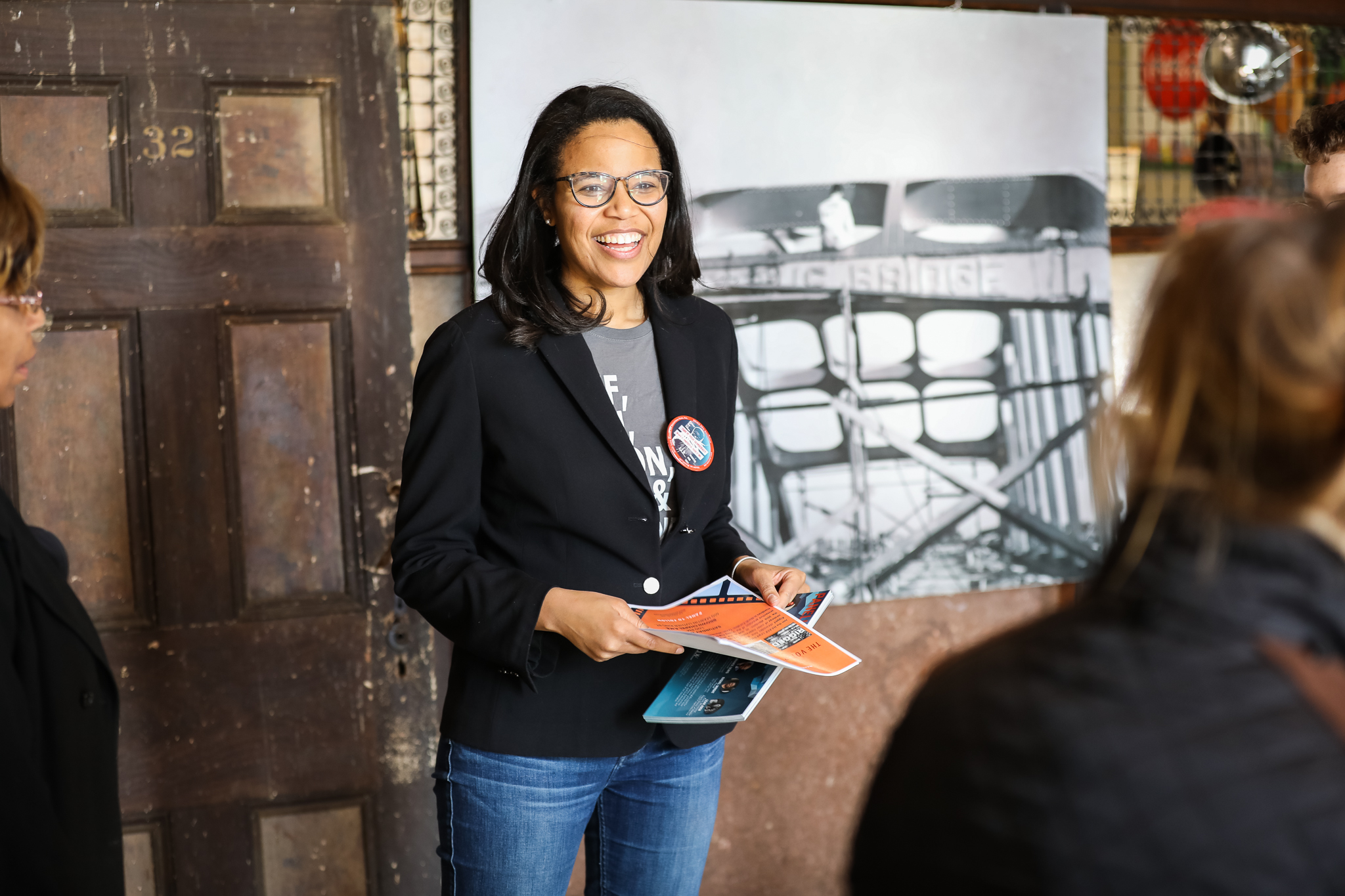 Woman smiling and handing out information sheets