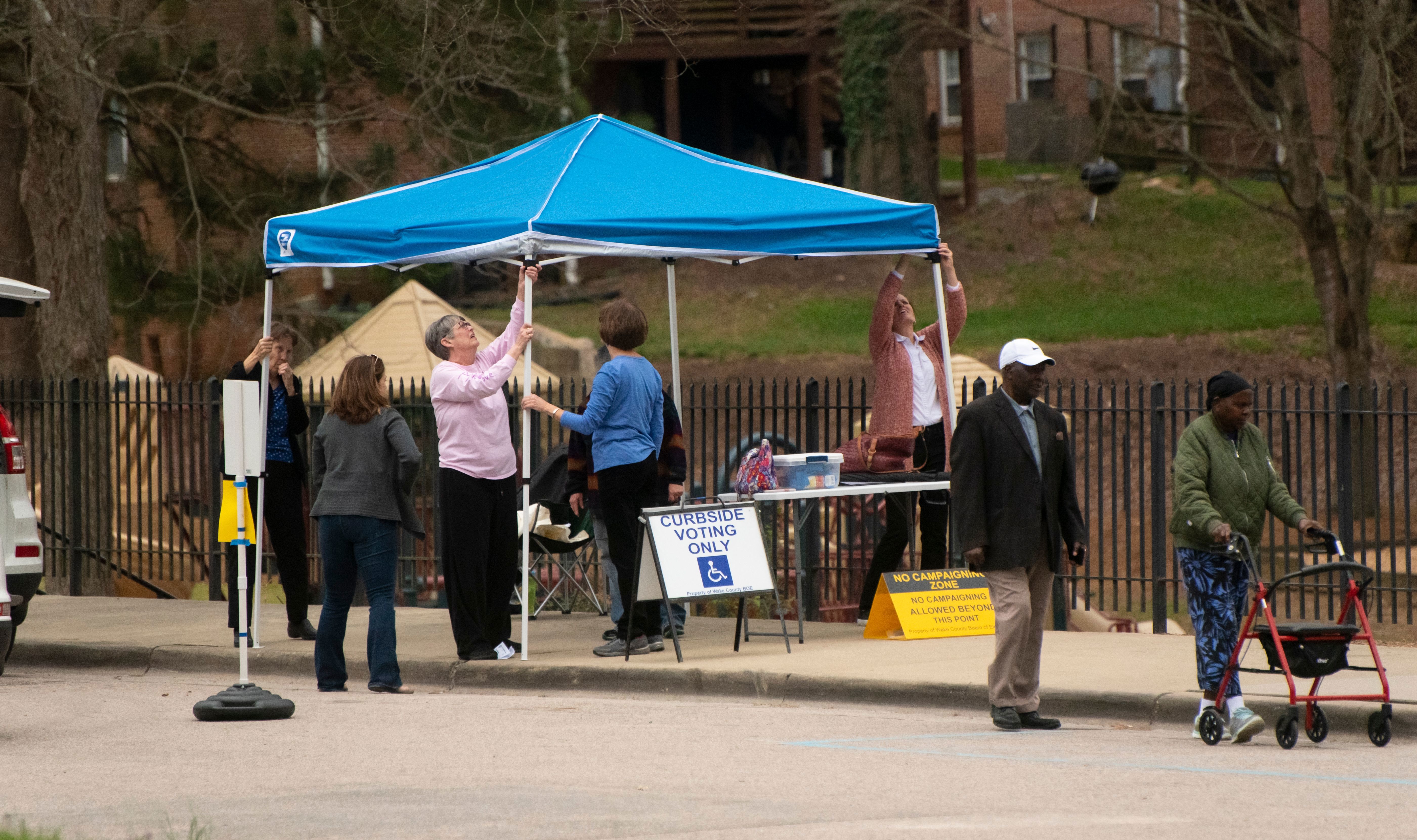 People assembling a curbside voting location